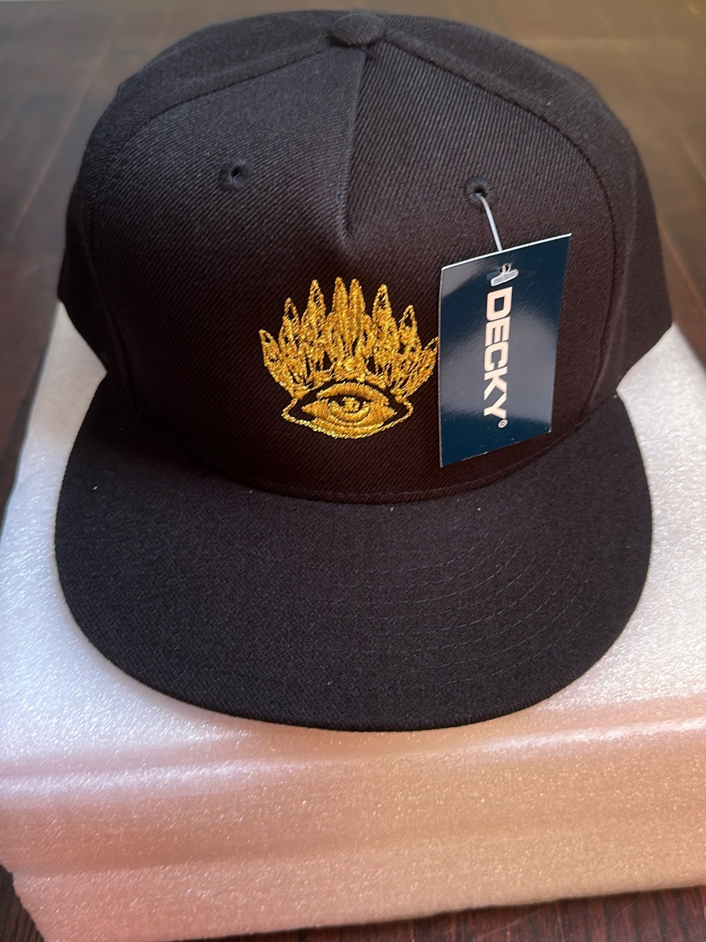 Decky Black Snapback Hat with Gold Embroidered Eye Graphic